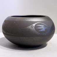 An avanyu design on a micaceous black jar