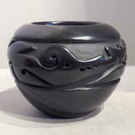 An avanyu design carved into a black jar