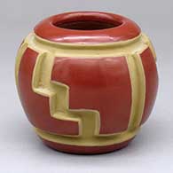 A small red jar decorated with a three-panel carved geometric design
 by Anita Suazo of Santa Clara