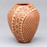 A small red jar with a two-panel sgraffito snowflake and geometric design
 by Wilma Baca Tosa of Jemez