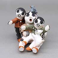 A small polychrome storyteller with two children, a kitten, a bird, and a ladybug