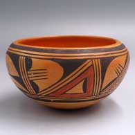 A polychrome bowl decorated with a band of geometric design around the exterior
