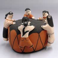 Several children leaning on a drum