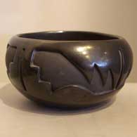 A black bowl carved with a kiva step and modified avanyu design