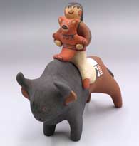 A child and her teddy bear riding on the back of a buffalo