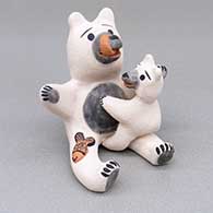 A black bear storyteller figure with a cub and a fish