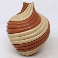 Buff and red jar carved with a spiral melon design