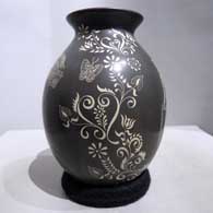 Sgraffito geometric design on a black and white jar