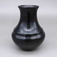 A plain, polished black water jar