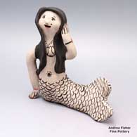 A black-on-white mermaid figure with a geometric design