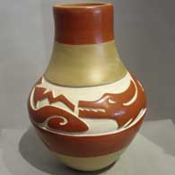 A red and buff jar carved with an avanyu design