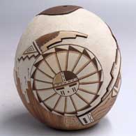 A polychrome seed pot lightly carved and painted with a longhair kachina, sun face, corn plant and geometric design
