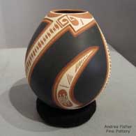 A polychrome jar with a lightkly carved and painted Paquime-derived geometric design