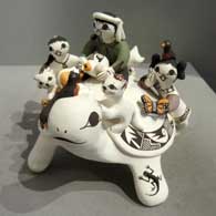 Turtle storyteller figure with three children Three children on a turtle storyteller figure
