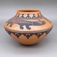 A black-on-golden micaceous jar decorated with a Mimbres-style lizard and geometric design
