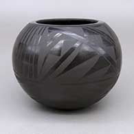A small black-on-black bowl decorated around the exterior with an <em>avanyu</em>, feather and geometric design