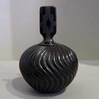 Lidded black jar carved with melon design Melon design carved into a lidded black jar
