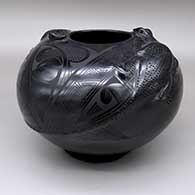A black-on-black jar with a pair of applique lizards rising from the middle to the rim