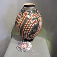 Lightly carved, sgraffito and painted geometric design on a large polychrome vase