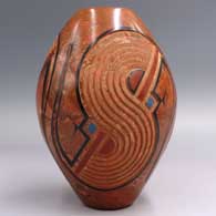 A polychrome mixed clay jar with a lightly carved and painted 3-panel geometric design