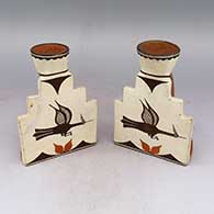 A pair of polychrome bookends with candle holders and a roadrunner and geometric design