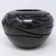 Black jar carved with an avanyu design