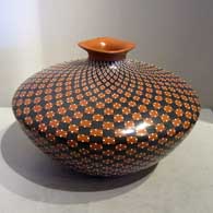 Red and black checkerboard design on a polychrome jar with a square-lipped opening