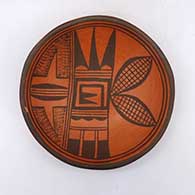 A black-on-red bowl decorated with a bird element and geometric design