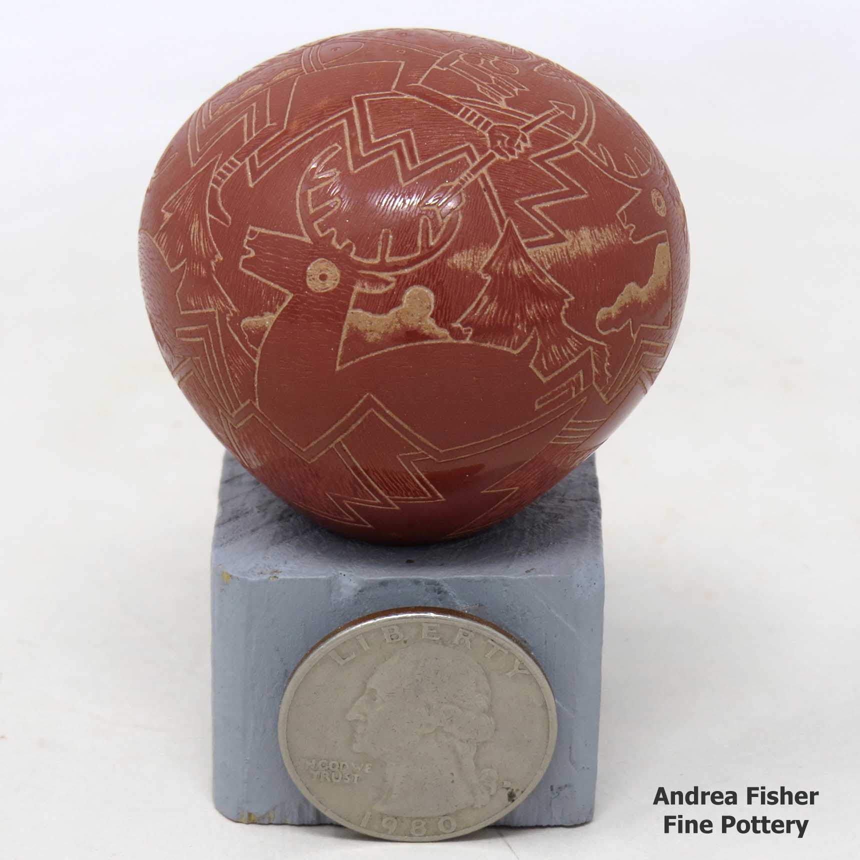 Click or tap to see a larger view Miniature red seed pot with sgraffito deer, hunter, nature and geometric design
made by Susan Romero of Santa Clara
