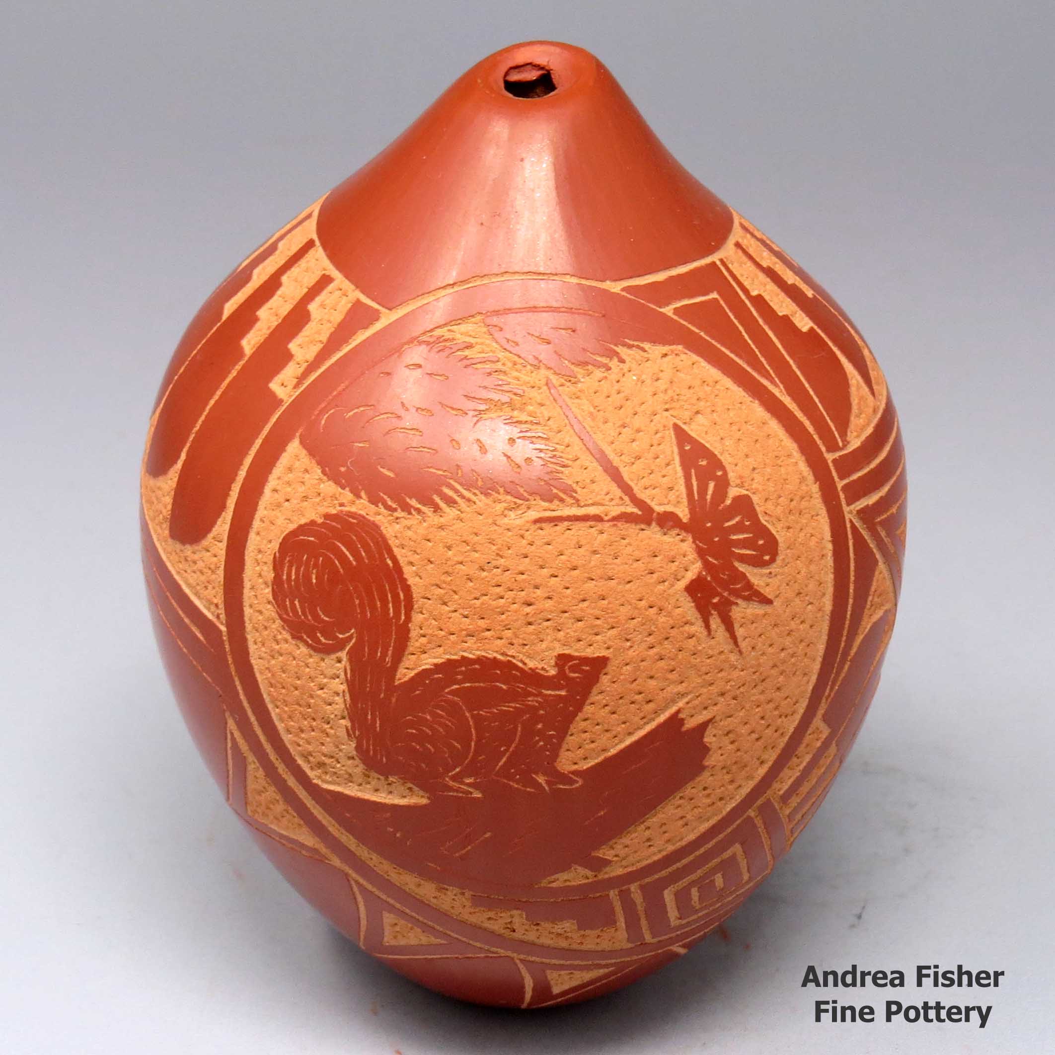 Vangie Tafoya created this piece, Click or tap to see a larger version Redseedpotwithasgraffitomedallionwithasquirrel,abutterflyandapinebranchsurroundedbyafeatherandgeometricdesign, Click or tap to see a larger version