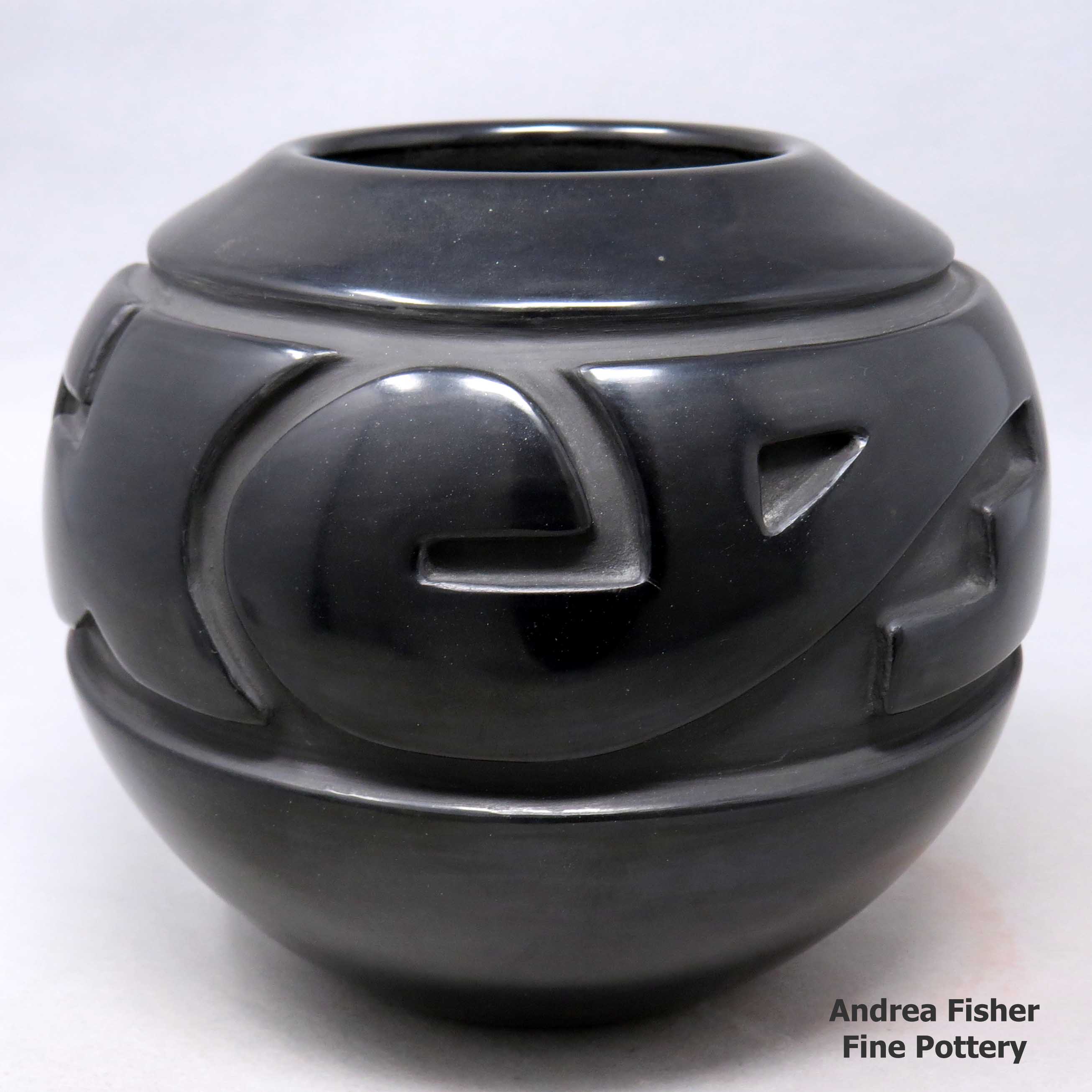 Click or tap to see a larger view Black jar carved with a styled avanyu and geometric design
made by Nathan Youngblood of Santa Clara