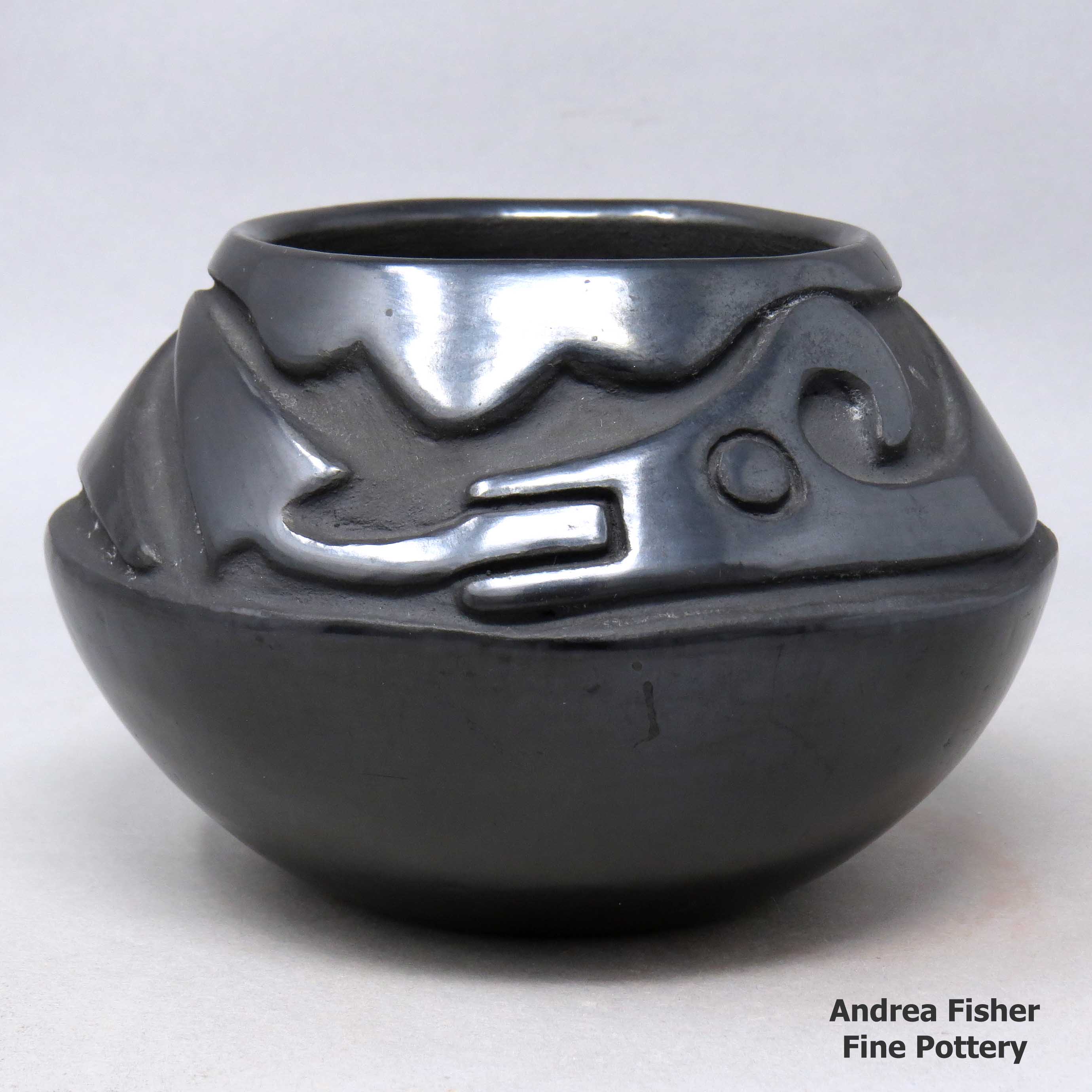 Click or tap to see a larger view Black jar carved with an avanyu design
made by Juanita Gonzales of San Ildefonso