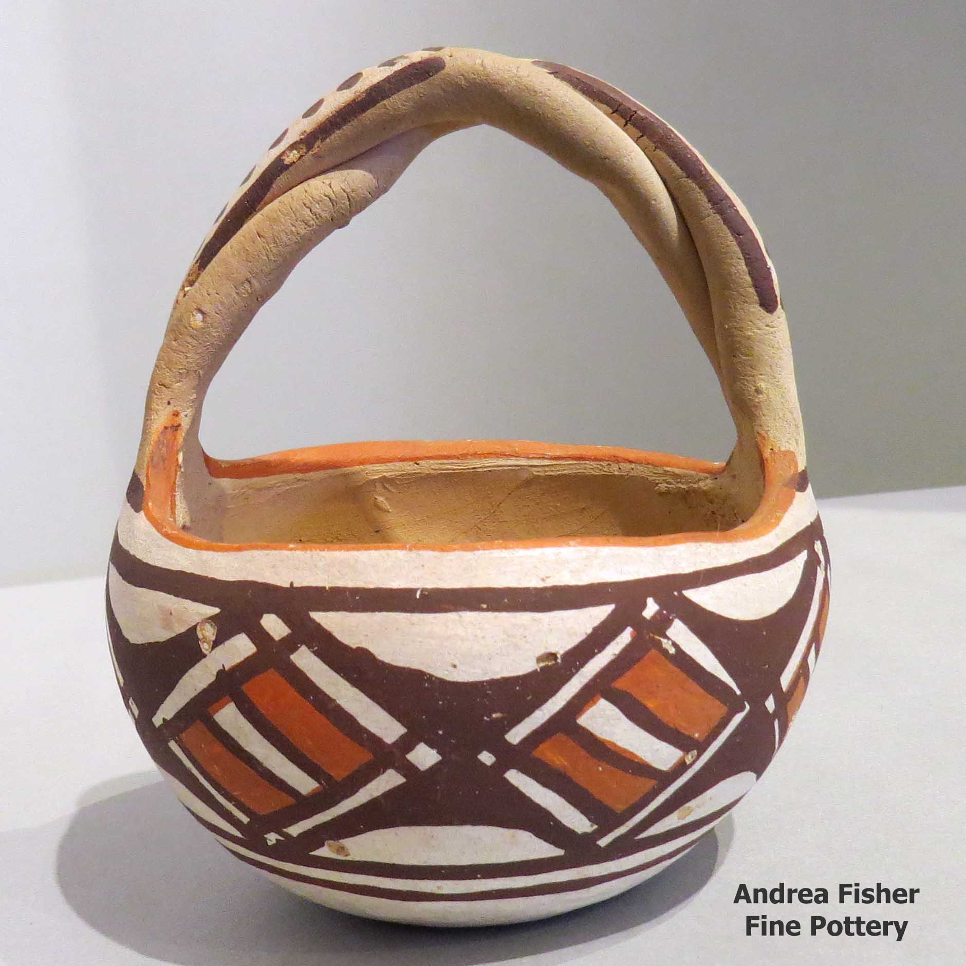 Click or tap to see a larger view Polychrome friendship basket with twisted handle and geometric design
made by Unknown of Isleta