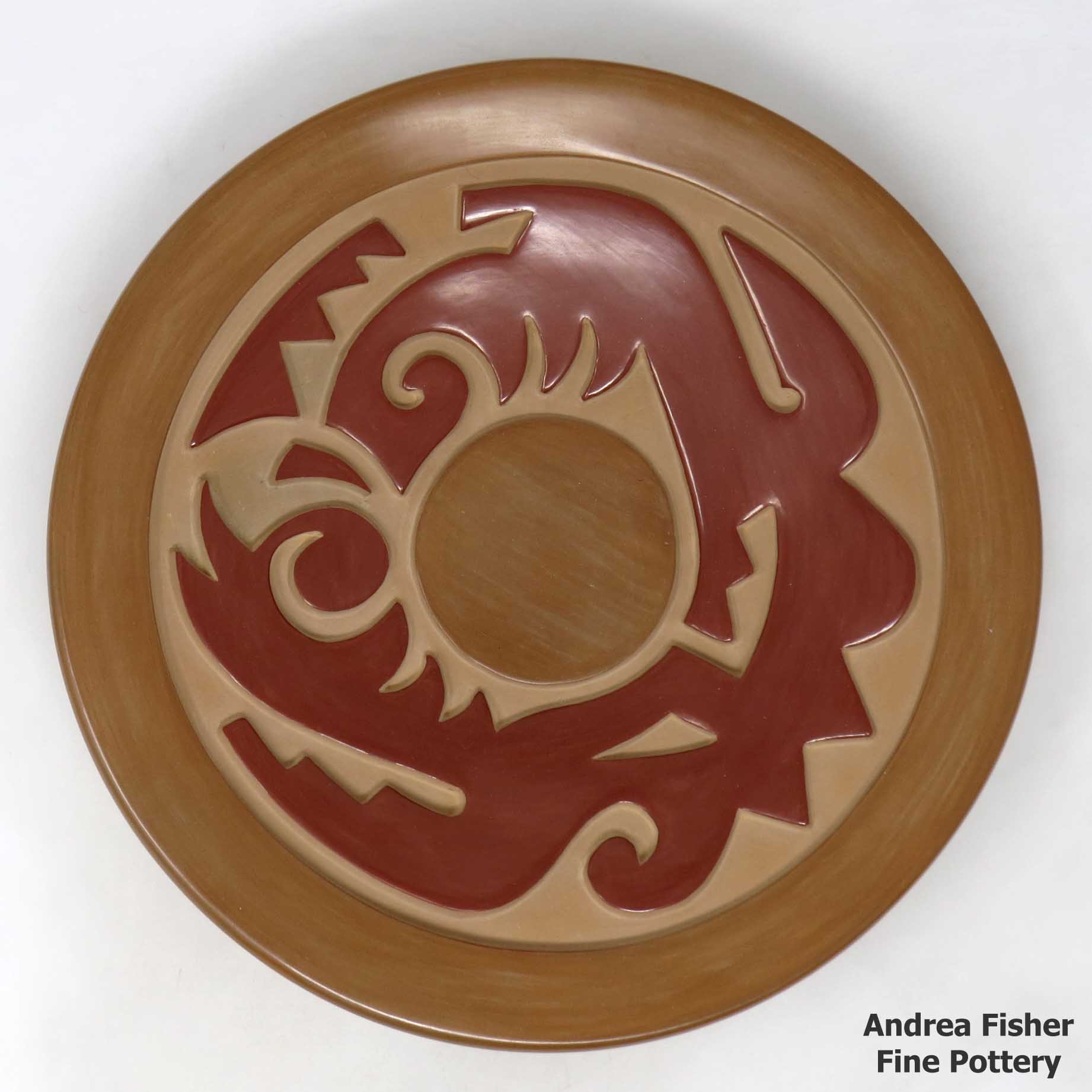 Click or tap to see a larger view Red and brown plate carved with stylized avanyu and geometric design
made by Nathan Youngblood of Santa Clara
