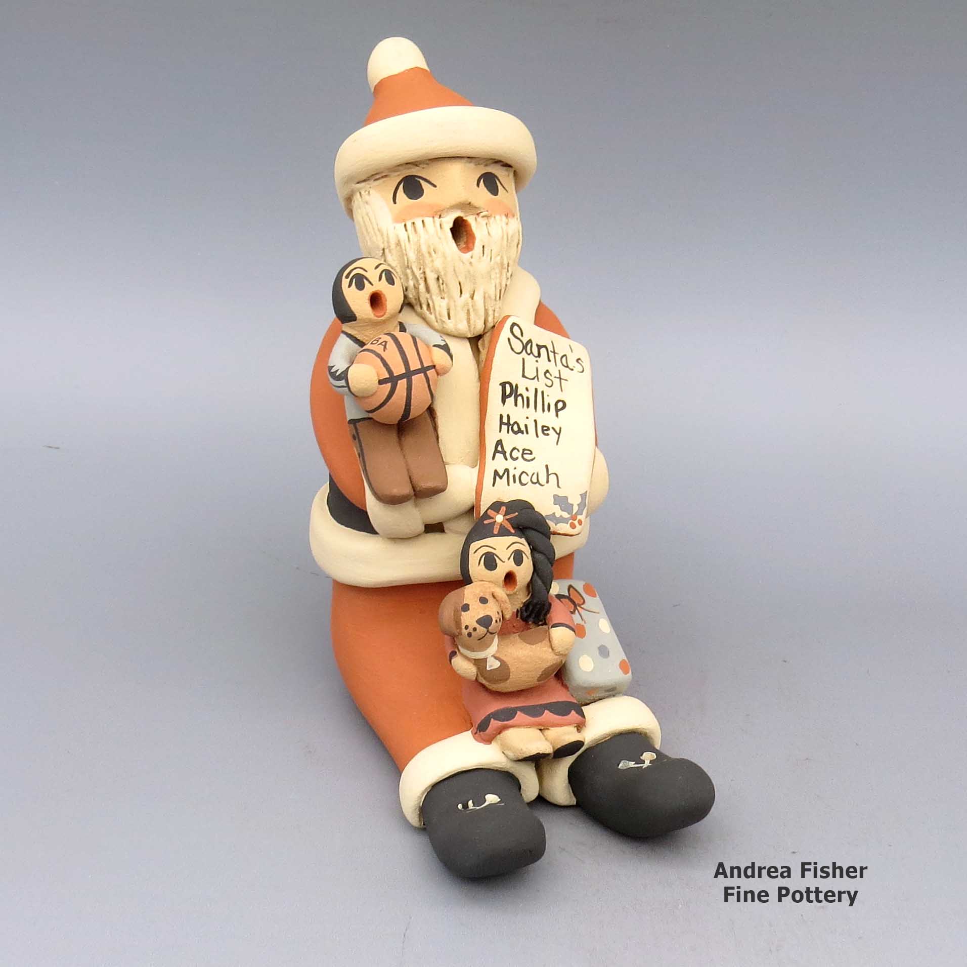 Polychrome Santa Claus storyteller with two children, basketball, puppy, list, and present made by Chrislyn Fragua of Jemez