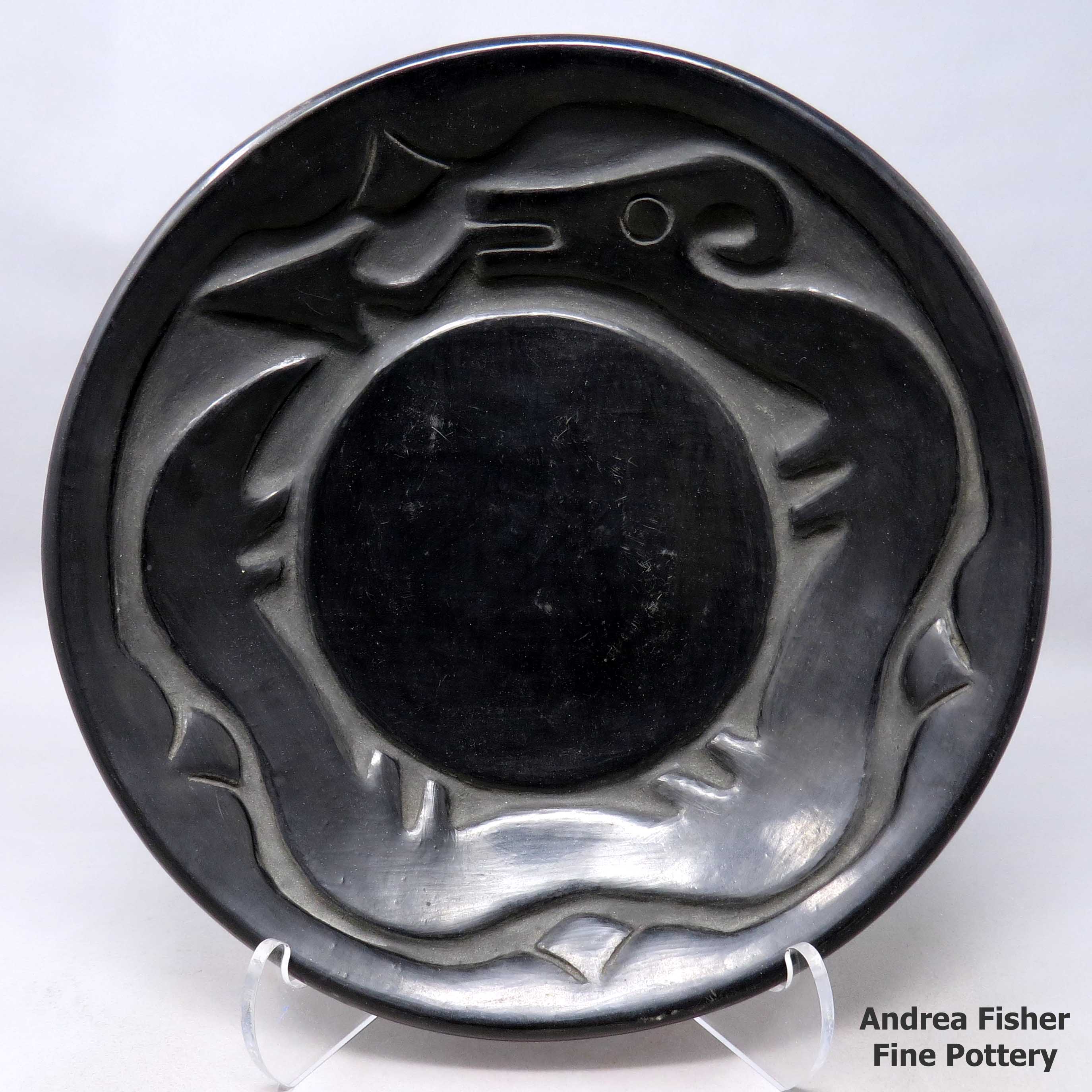 Click or tap to see a larger view Shallow black bowl carved with an avanyu and geometric design
made by Rose Gonzales of San Ildefonso
