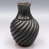 Black jar with a scalloped rim and body carved with a spiral melon design
 by Emma Yepa of Jemez