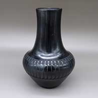 Black-on-black jar with a tall, slightly flared neck and a painted feather ring geometric design, drilled on the bottom for a lamp
 by Maria Martinez of San Ildefonso