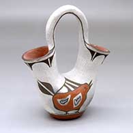 A polychrome wedding vase with a bird design on one side and cloud forms around the spouts
 by Annette Raton of Santa Ana