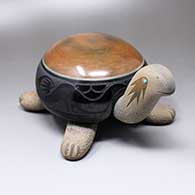 A polychrome turtle figure with sienna spots and a black shell decorated with a sgraffito double avanyu design
 by Tony Da of San Ildefonso
