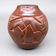 Red jar with a carved buffalo-with-heart-line, feather ring, spiral, and geometric design
 by Harrison Begay Jr of Santa Clara
