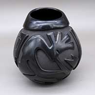 Black jar with an asymmetrical opening and a carved kokopelli and geometric design
 by Rosemary Lewis of Santa Clara