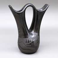 A black-on-black wedding vase decorated with an avanyu and geometric design
 by Unknown of Santa Clara