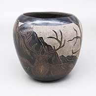 Black jar with sienna spots and a sgraffito deer, mountain, tree, and grass design
 by Martin Moquino of Santa Clara