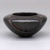 A small black bowl carved with a bear figure and with sgraffito bear paws a heart line
 by Effie Garcia of Santa Clara
