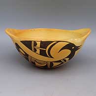 Black on yellowware bowl with handles, bird design, and fire clouds
 by Unknown of Hopi