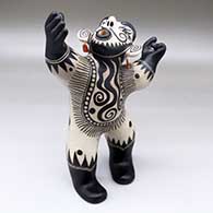 Large black-on-white standing opera singer figure decorated with geometric designs, original earrings have been replaced
 by Virgil Ortiz of Cochiti