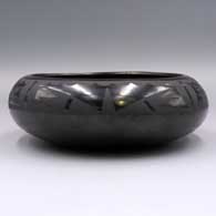 Black-on-black bowl with a 4-panel geometric design above the shoulder
 by Maria Martinez of San Ildefonso