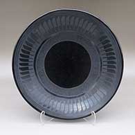 Black-on-black plate with a feather ring and geometric design
 by Maria Martinez of San Ildefonso