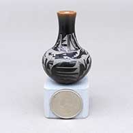 Miniature black jar with a tall neck, a flared opening, a sienna rim, and a sgraffito avanyu, kiva step, and geometric design
 by Geri Naranjo of Santa Clara